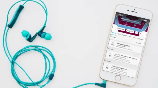 Smartphone with headphones, displaying a music app on a white background.